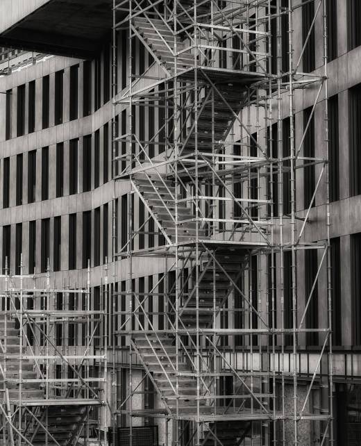 Vertical grayscale shot of a staircase outside a building used for the reconstruction A vertical grayscale shot of a staircase outside a building used for the reconstruction